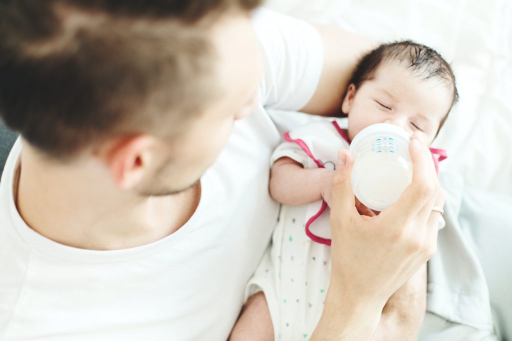 Young white father feeding baby with bottle