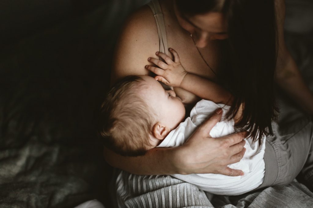 Mom brunette breastfeeding toddler. concept breastfeeding life style,