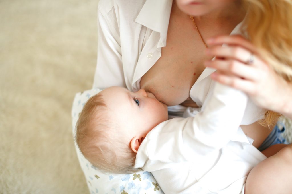 tender Caucasian mother breastfeeds her baby
