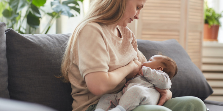 Mature Woman Breastfeeding Baby at Home