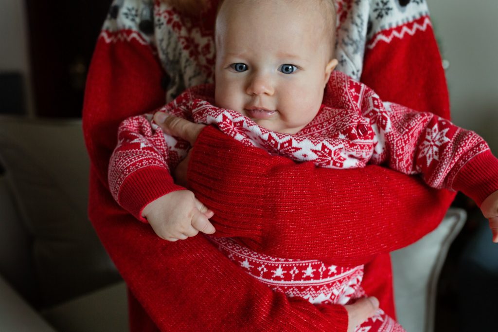 Mother with baby daughter at home during Christmas holidays.