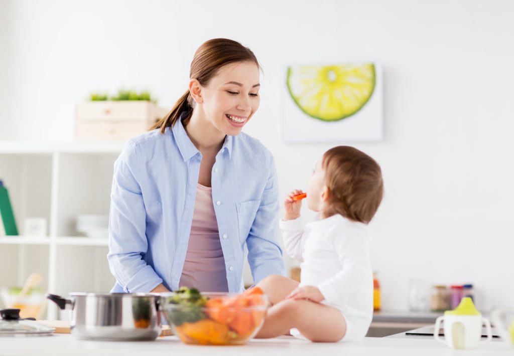 happy mother and baby eating at home kitchen