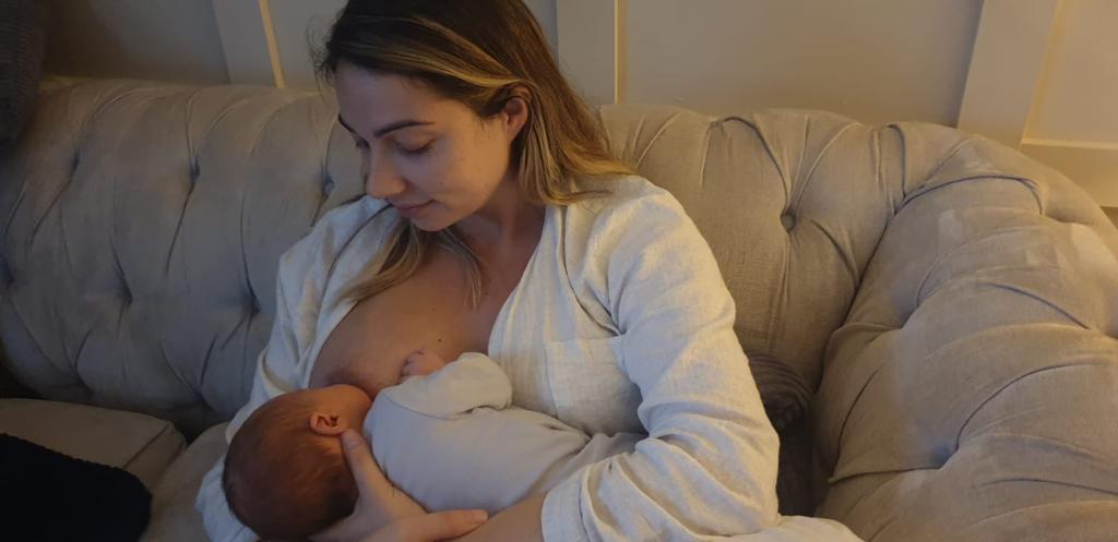 breastfeeding mother showing how to use the cross cradle hold