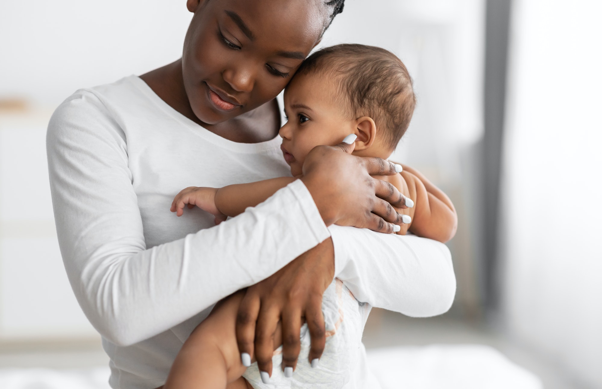 Portrait of black mother holding baby on hands