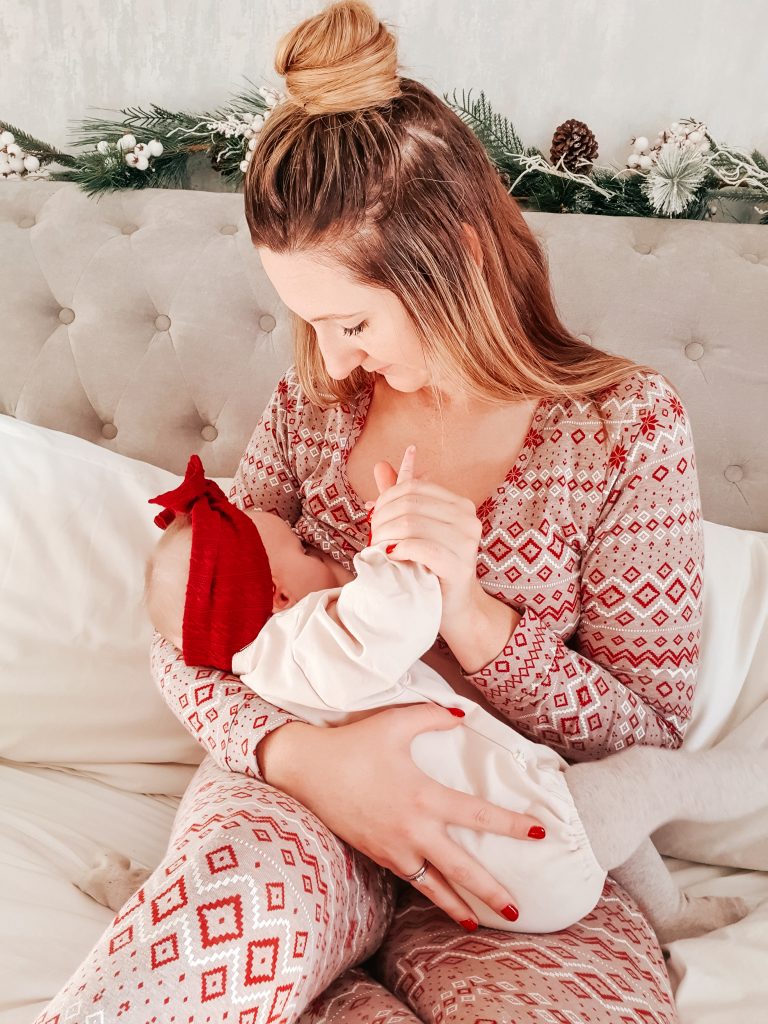Chantelle from The English Family breastfeeding daughter on a bed at Christmas