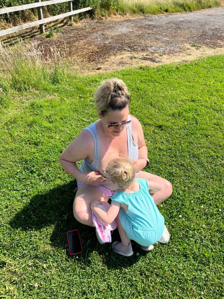Leane breastfeeding toddler outside