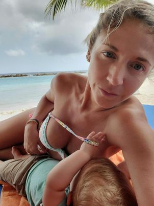 Mia breastfeeding son on beach