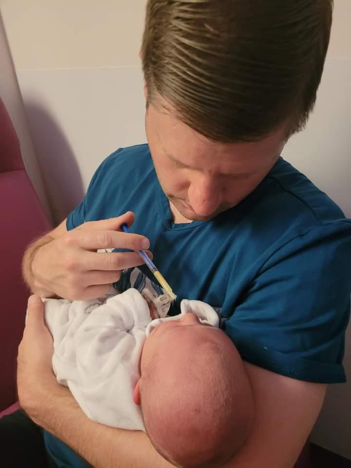giving newborn baby Walt colostrum from a syringe