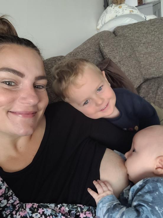 Grace breastfeeding newborn whilst toddler son cuddles her