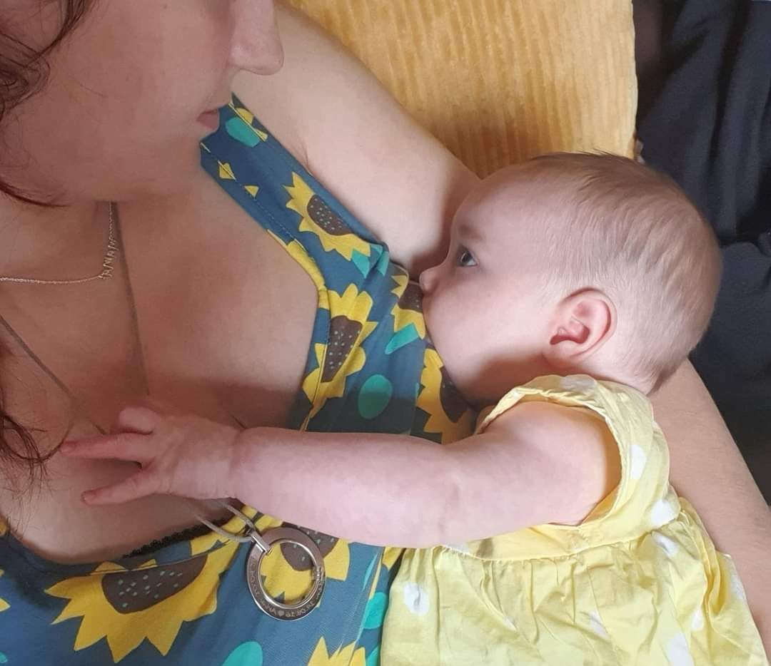 mother nursing baby in summer dress
