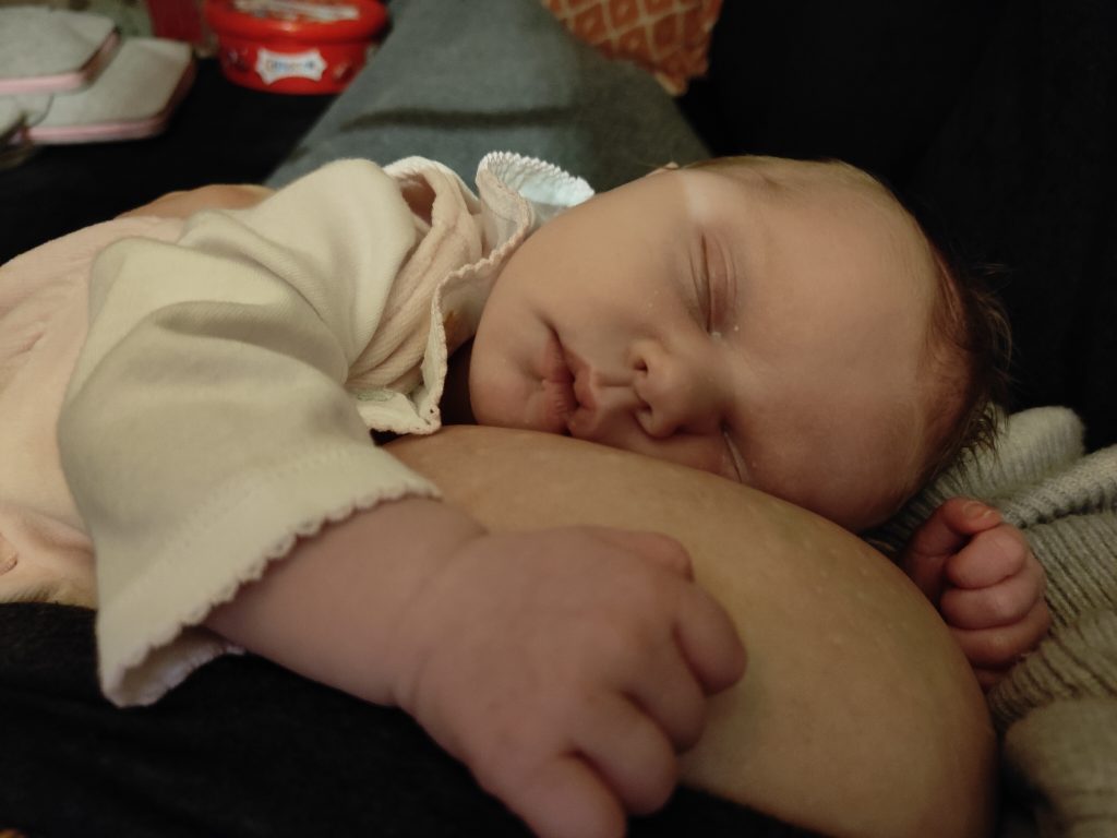 Baby sleeping against her sick breastfeeding mama