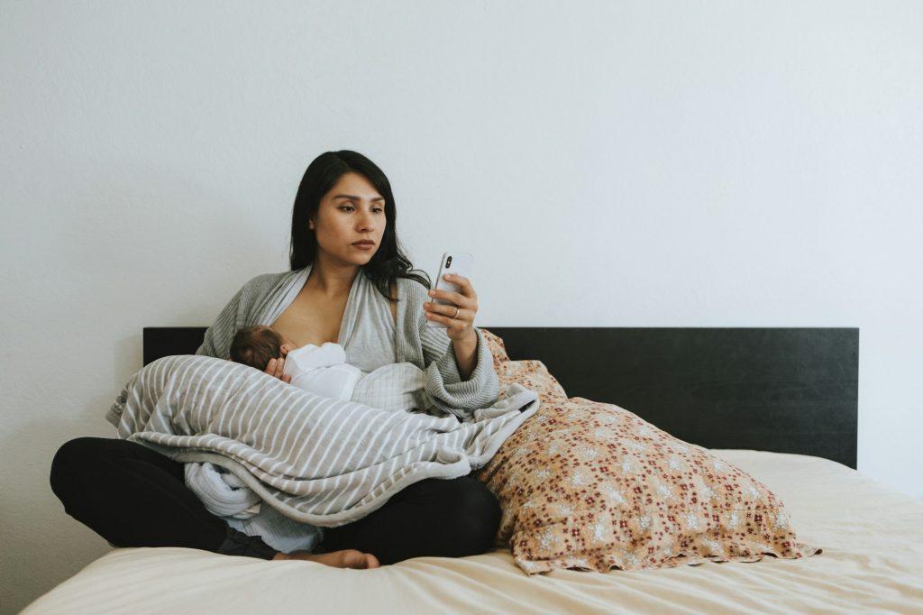 Breastfeeding mother using a smartphone