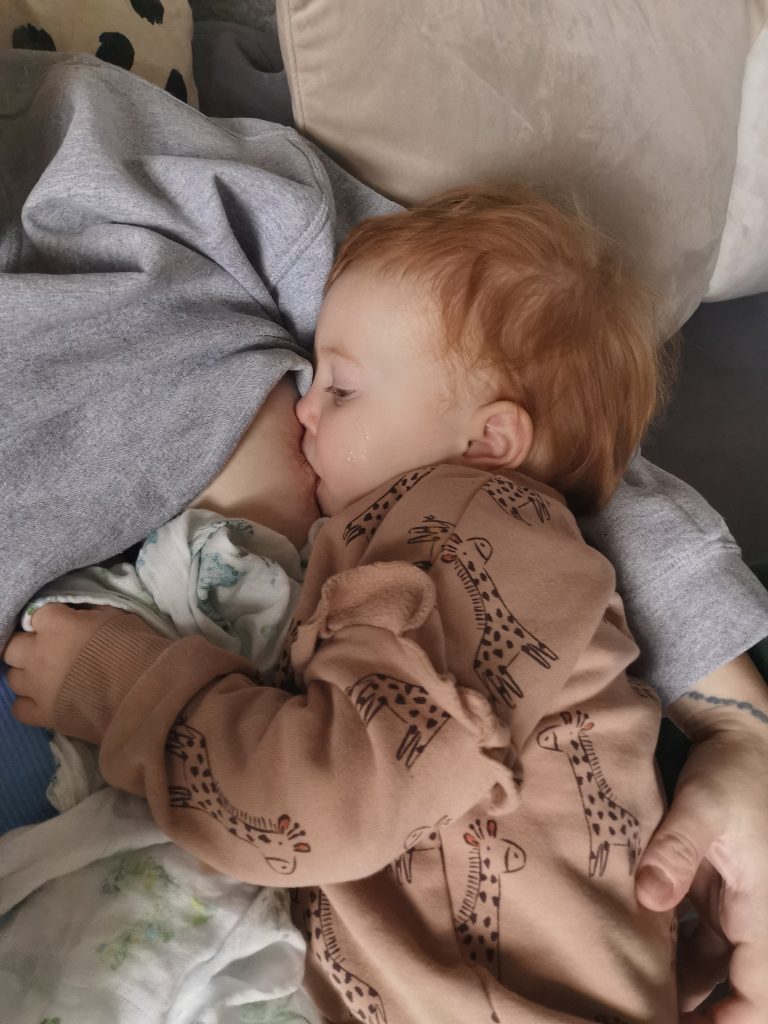 toddler breastfeeding and using a comforter