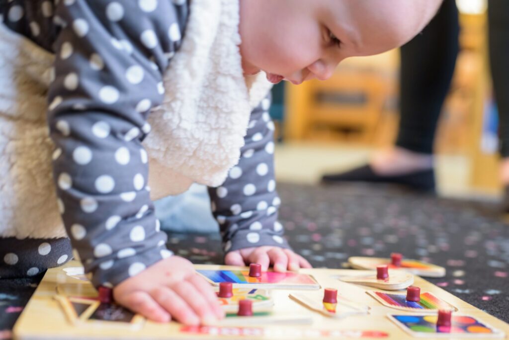 Baby in Halloween costume playing with a puzzle