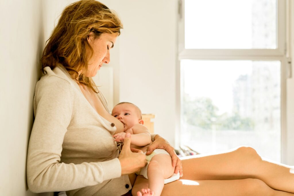 Baby breastfed by his mother in bed quiet in the morning, healthy motherhood concept.