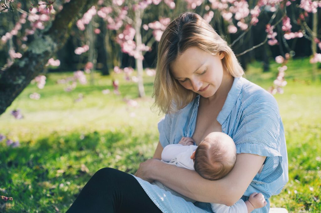 Beautiful mother breastfeeding baby. Young woman breast feeding her newborn baby.