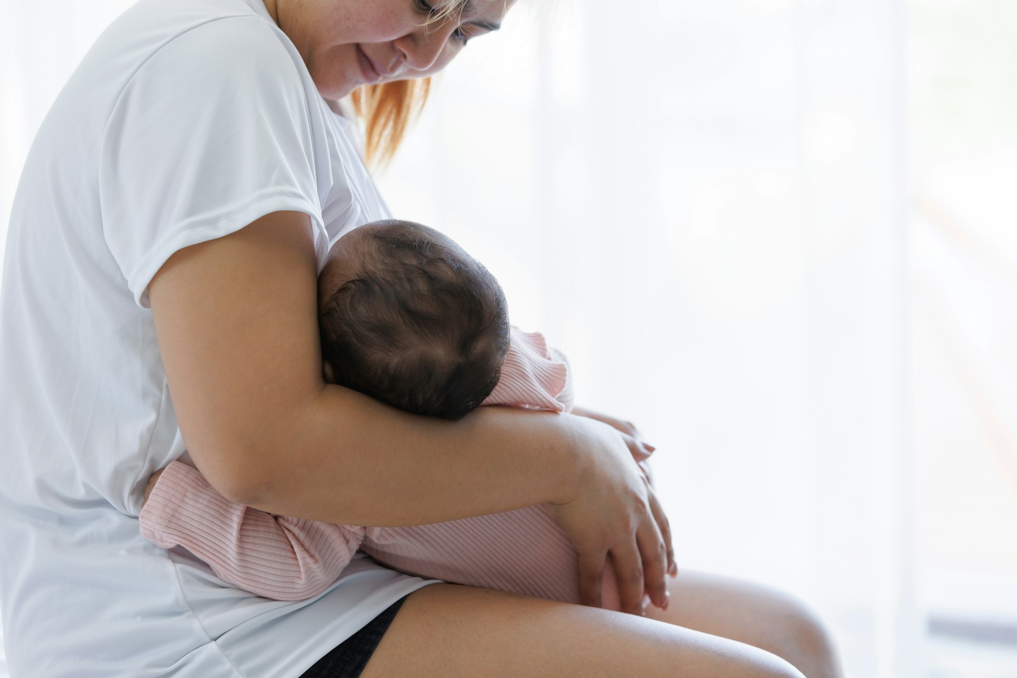 A happy mother is breast-feeding baby.