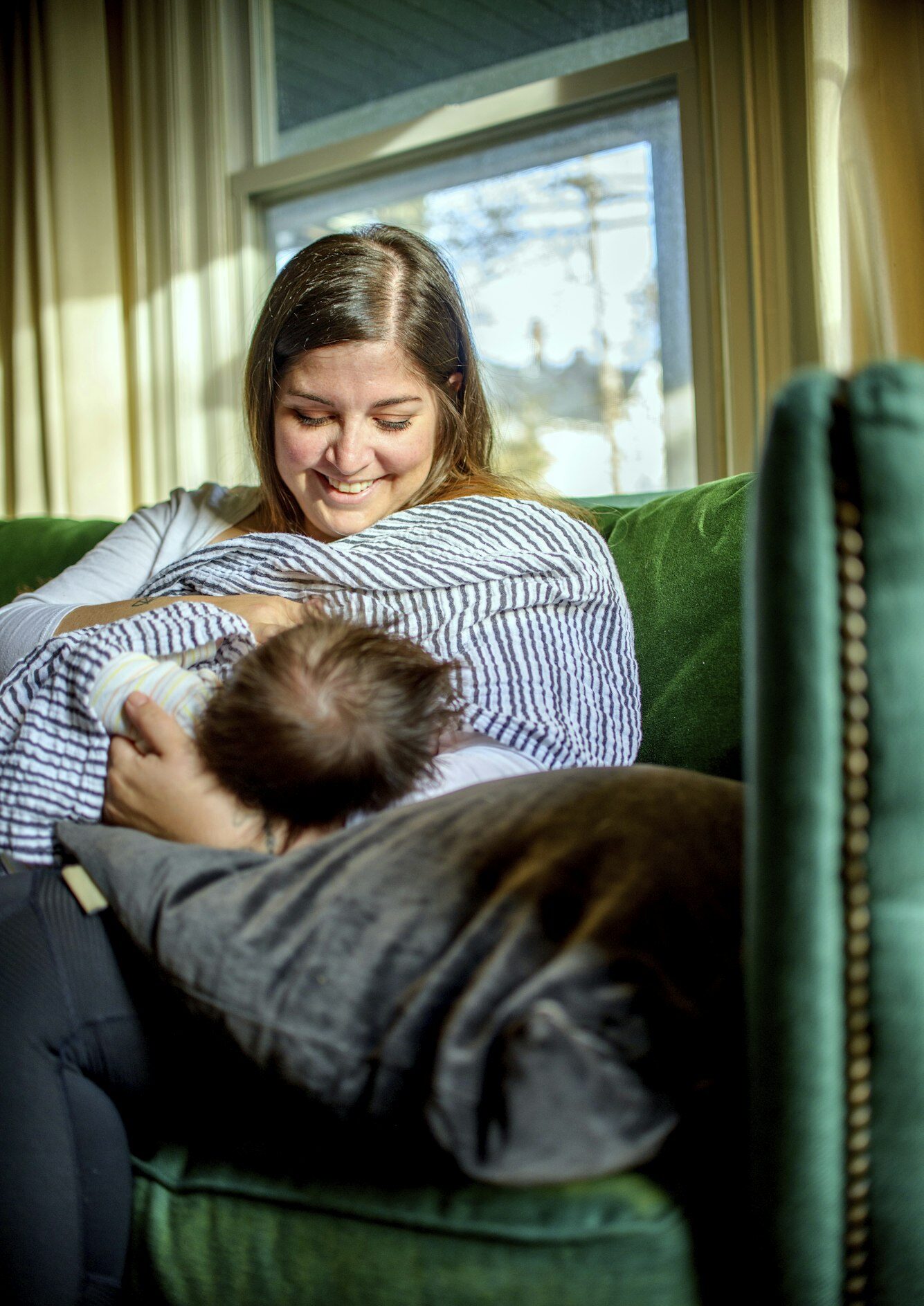 Mother breastfeeding baby on sofa