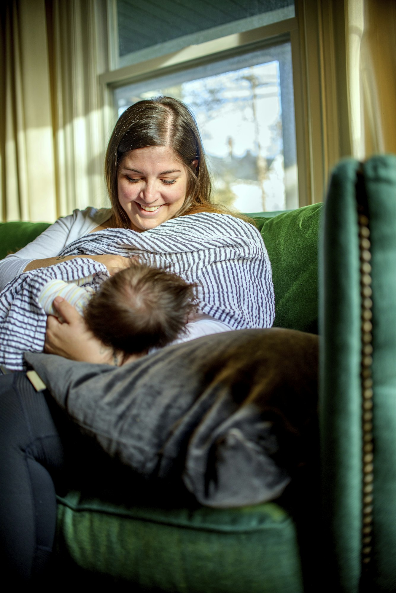 Mother breastfeeding baby on sofa