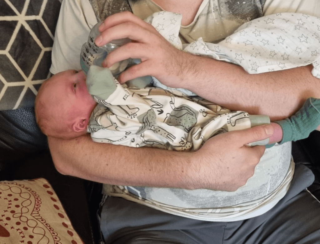 Dad bottle feeding baby son 