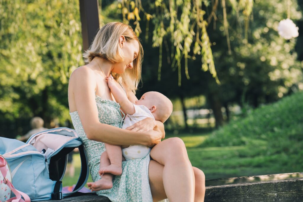 Beautiful mother breastfeeding baby. Young woman breast feeding her newborn baby.