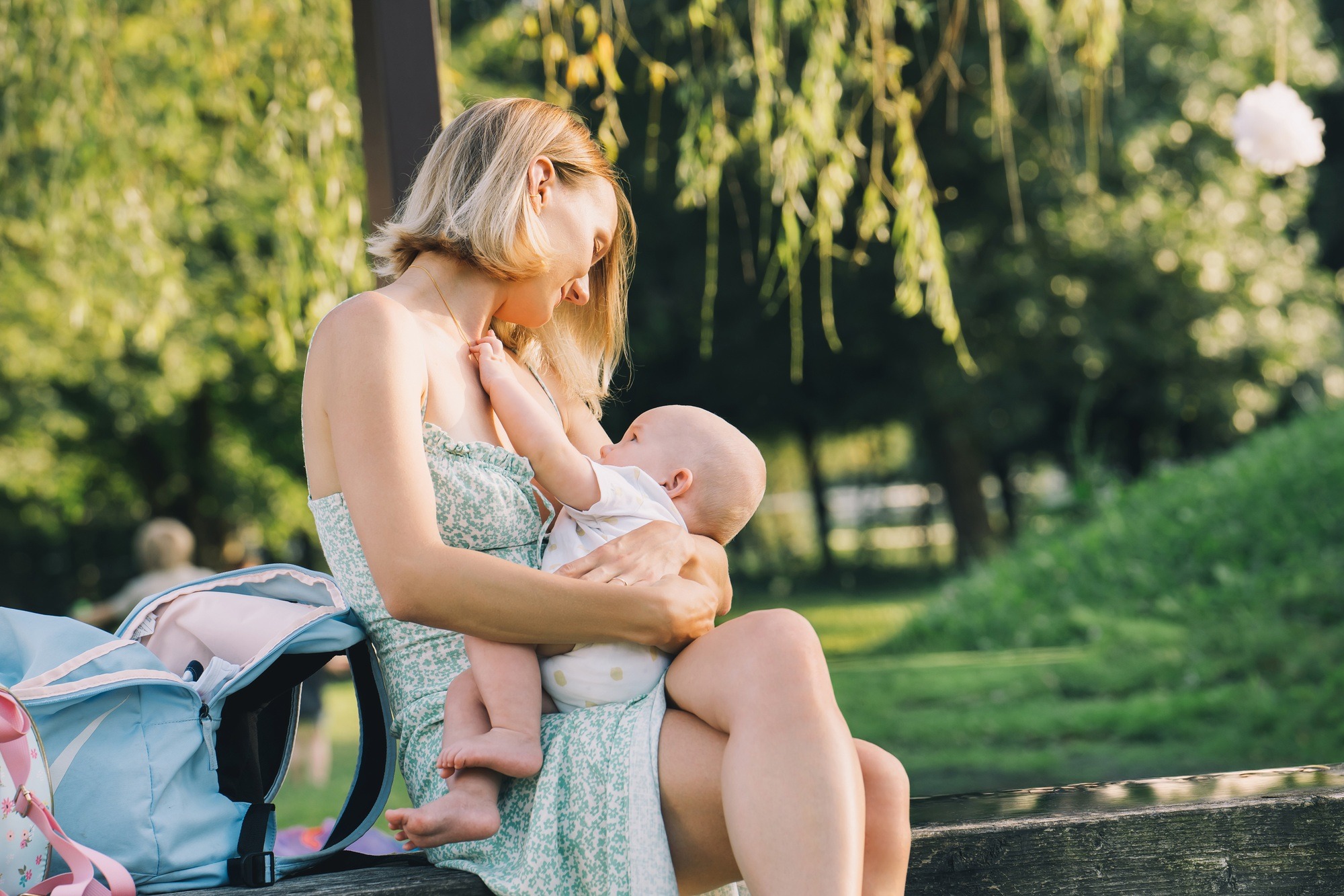 Beautiful mother breastfeeding baby. Young woman breast feeding her newborn baby.