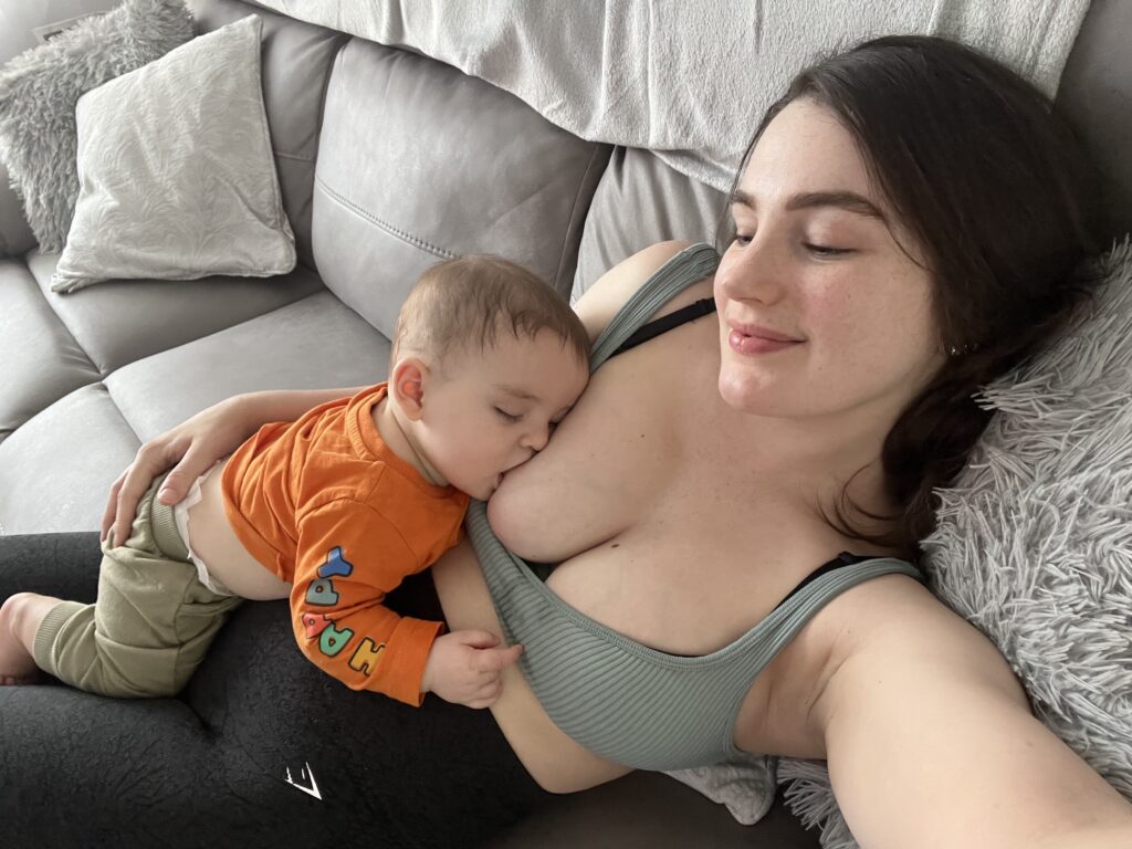 Anni Valentine breastfeeding her son on the sofa