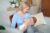 Beautiful blonde woman holding her little kid, breastfeeding
