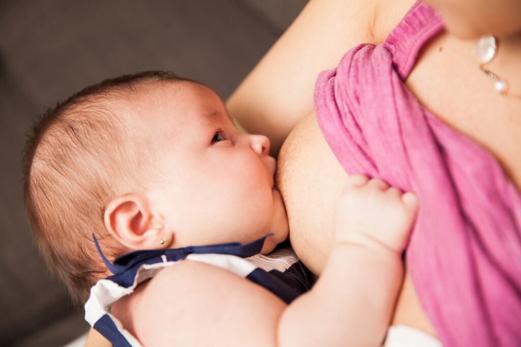 Breastfeeding baby looking at her mom