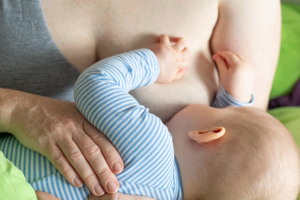 Caucasian mother breastfeeding a baby boy.