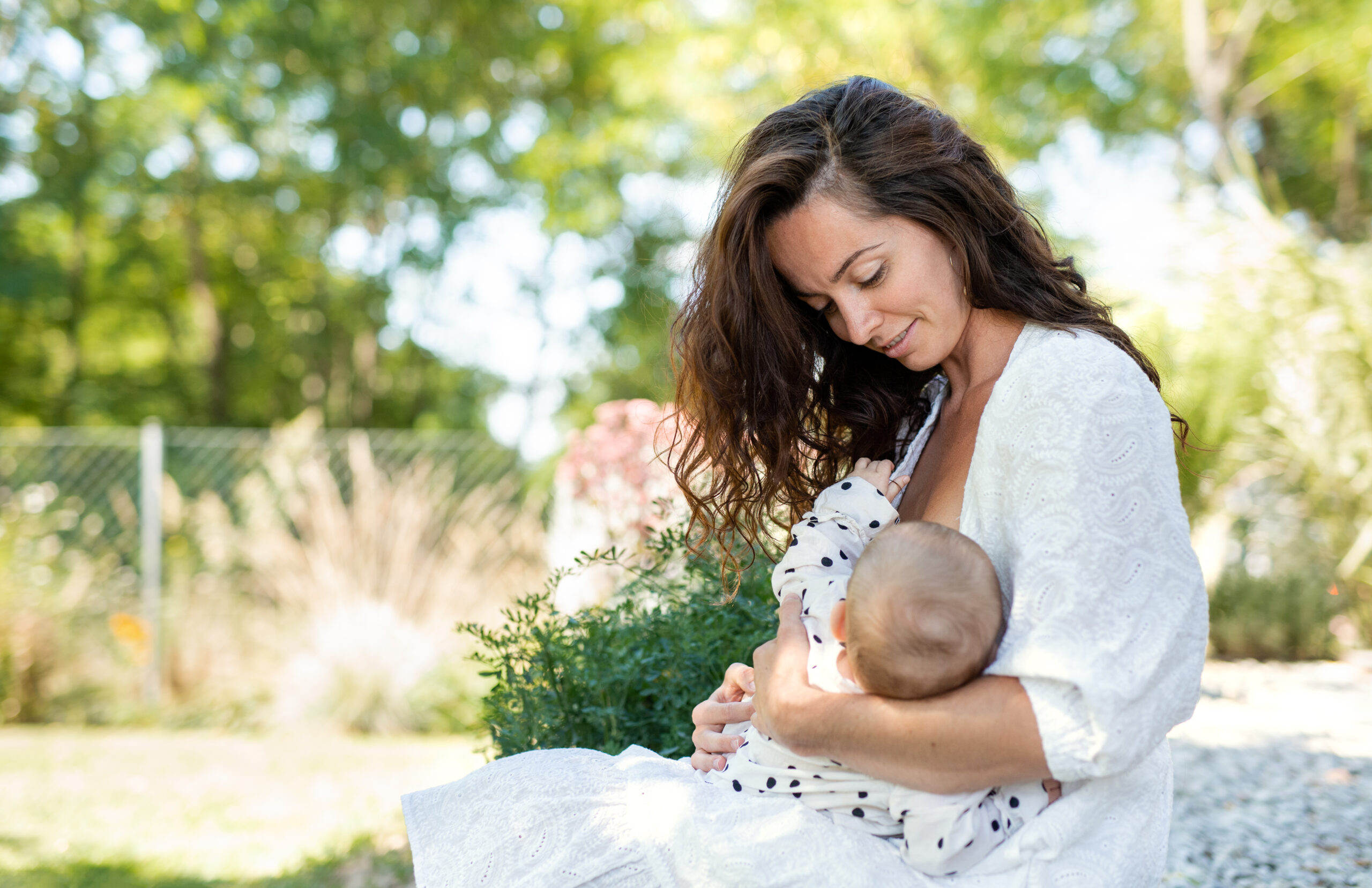 mother breastfeeding outside in nature and looking content