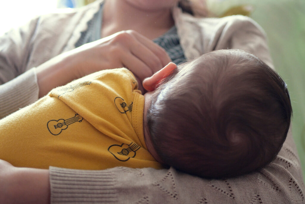 close up of back of baby's head as they breastfeed
